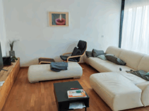 Wohnzimmer der WG mit Sofa, Sesseln und Couchtisch