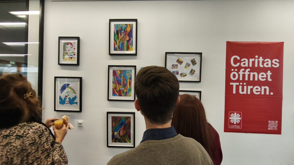 Besucher betrachten die Kunstwerke an den Wänden